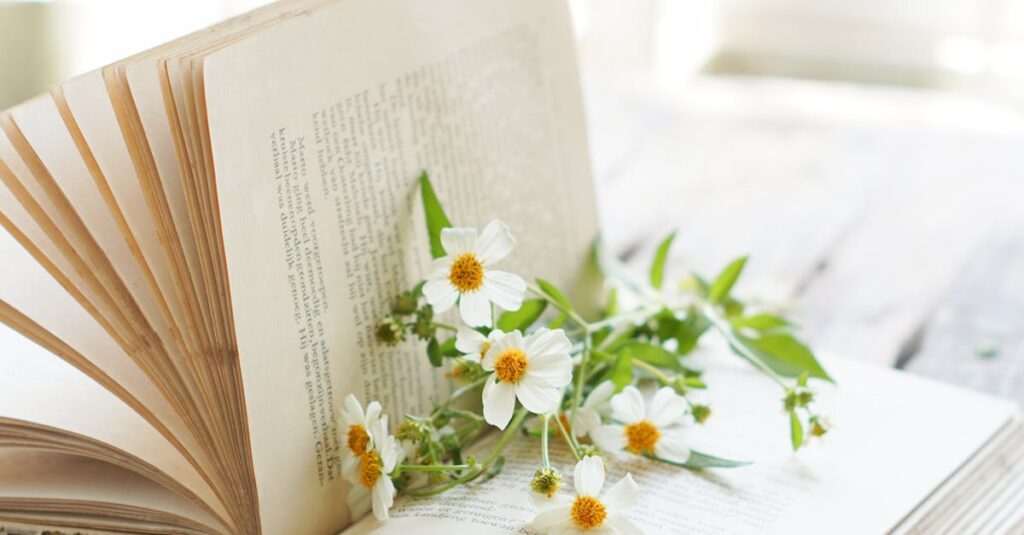 An open book with wildflowers resting on its pages on a rustic wooden table, evoking a sense of tranquility and nature.