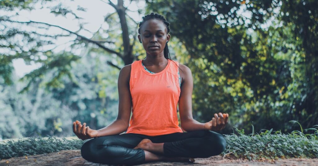 A woman meditating peacefully outdoors in a lush green setting, promoting relaxation and mindfulness.